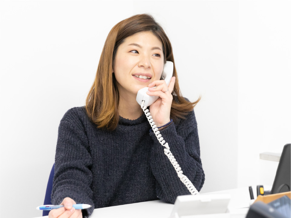 お客様からの電話対応中の坂本
